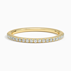 Gold moissanite eternity band with round gemstones in a pavé setting on white background