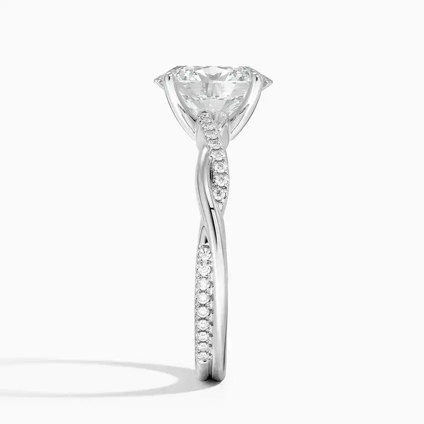 Moissanite engagement ring with twisted pavé band in white metal on white background