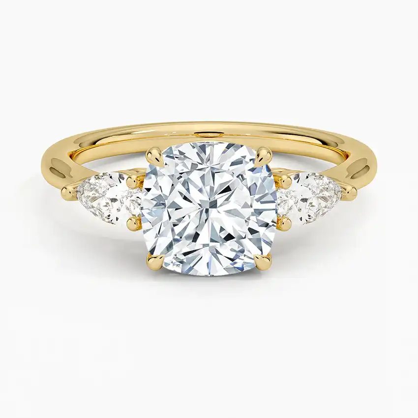 Gold moissanite engagement ring with cushion-cut center stone and two pear-shaped side stones