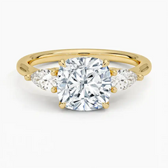 Gold moissanite engagement ring with cushion-cut center stone and two pear-shaped side stones