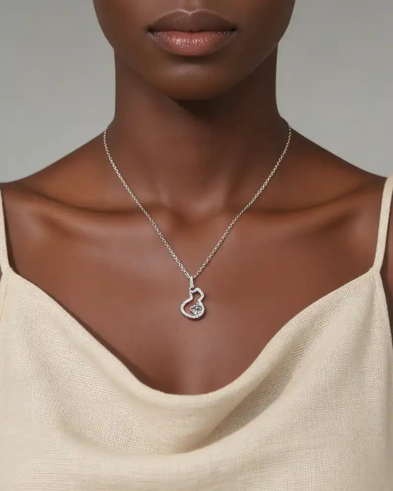Woman wearing a moissanite pendant necklace on a silver chain, minimalist outfit.