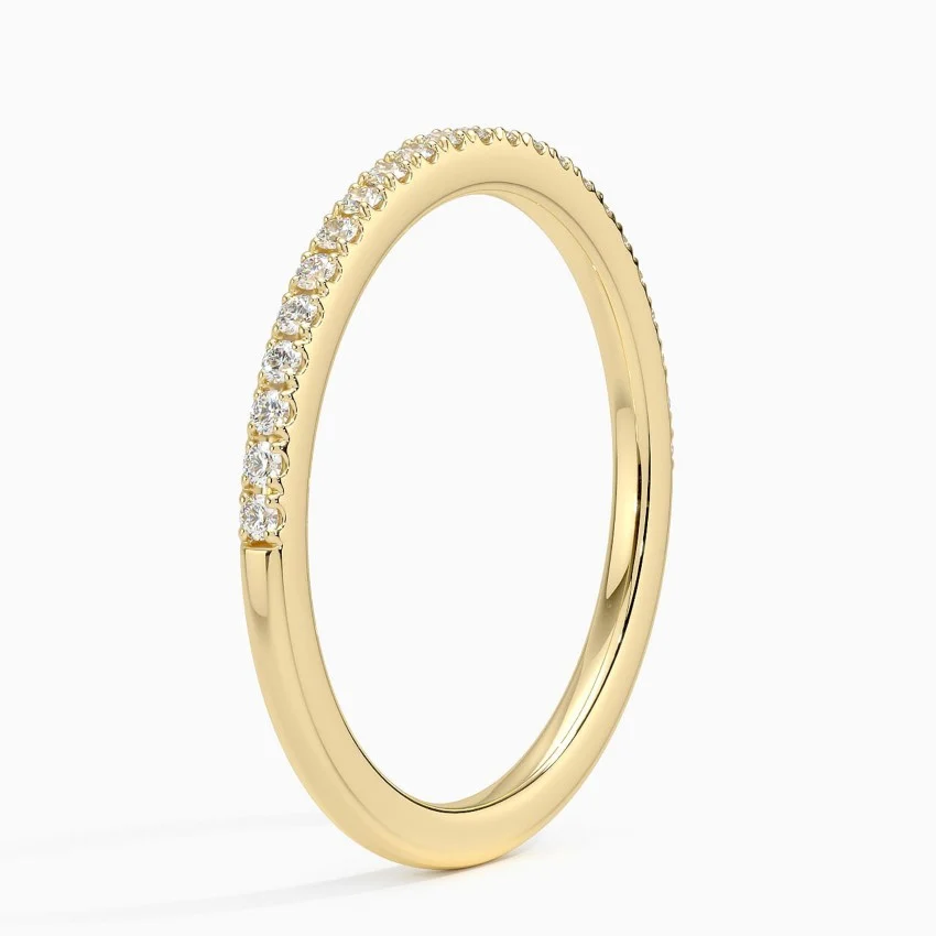 Thin gold band with small round moissanite stones in pavé setting on a white background.