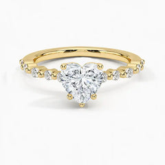 Heart-shaped moissanite engagement ring with gold band and diamond accents