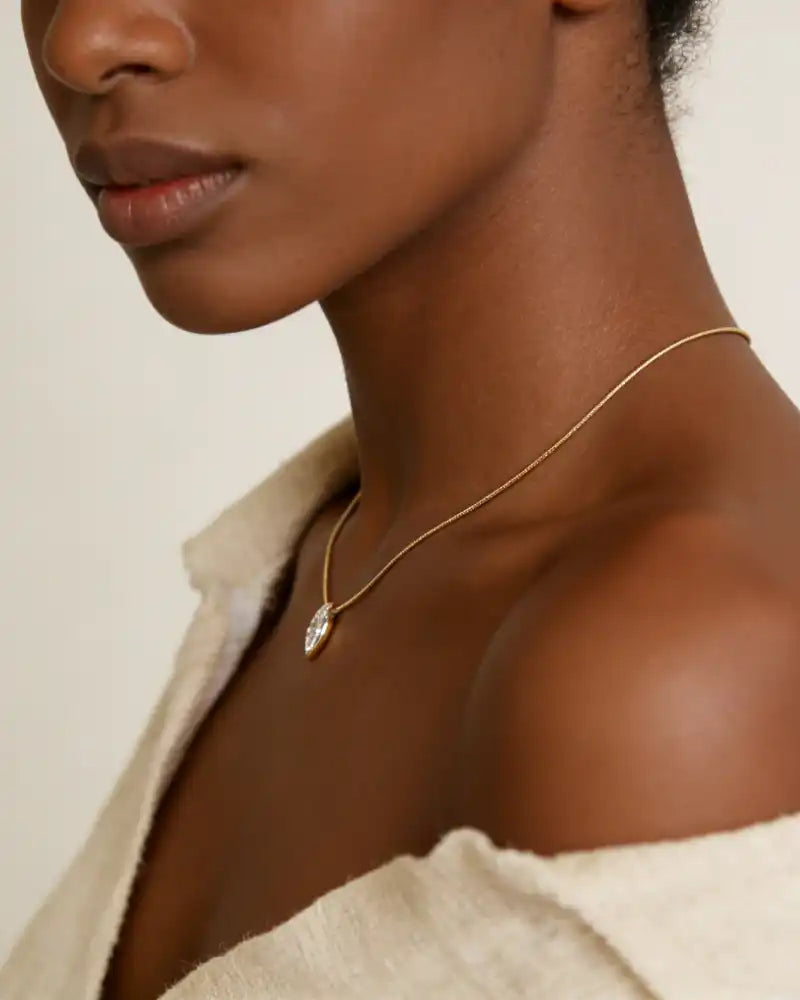 Woman wearing a gold moissanite pendant necklace, elegant and minimalist style
