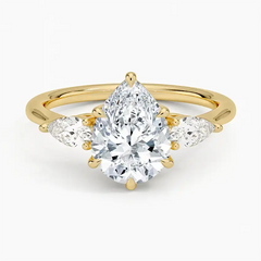Gold band ring with pear-shaped moissanite center stone and side stones, luxury jewelry