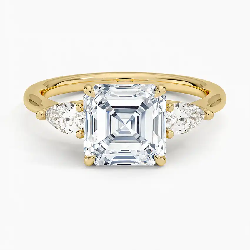 Asscher cut moissanite ring in yellow gold with pear side stones, elegant jewelry